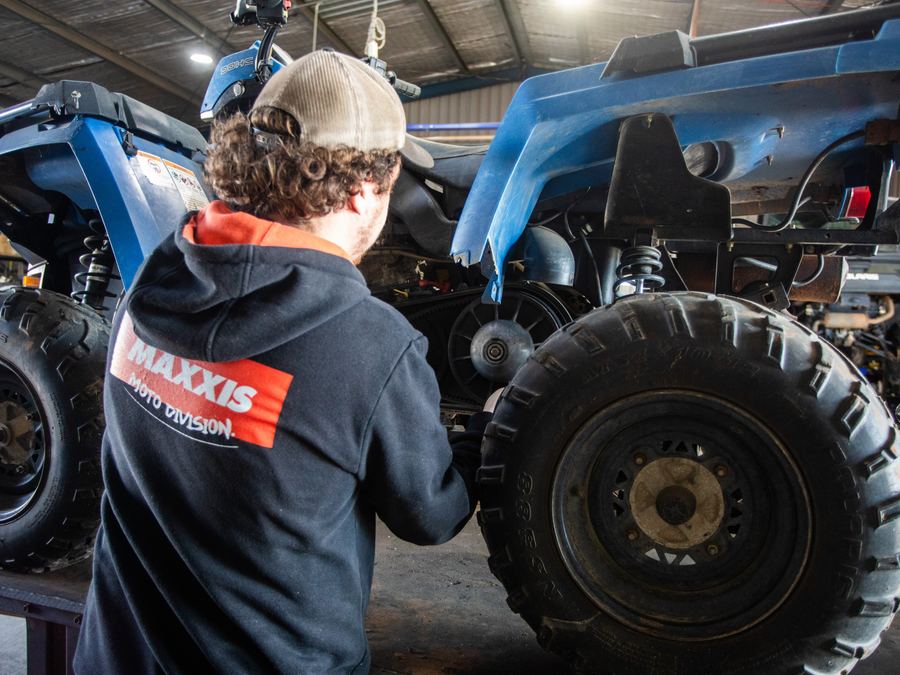 Mechanic servicing a quad bike in the Forbes Small Engine Specialists workshop
